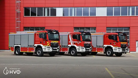 TLF 4000 독일 Großenhain, Röderaue and Ebersbach 납품 사진, 붉은 외벽 건물 앞에 차량 세 대가 나란히 선 모습